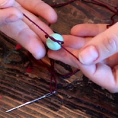 Tying a bead to the thread